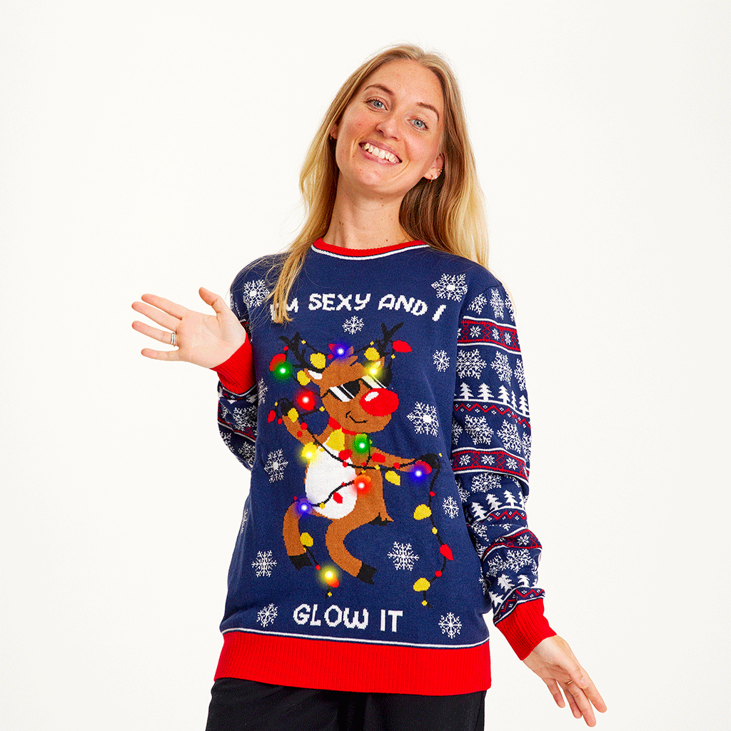 Une femme portant un pull bleu de Noël avec un renne dansant et des lumières.